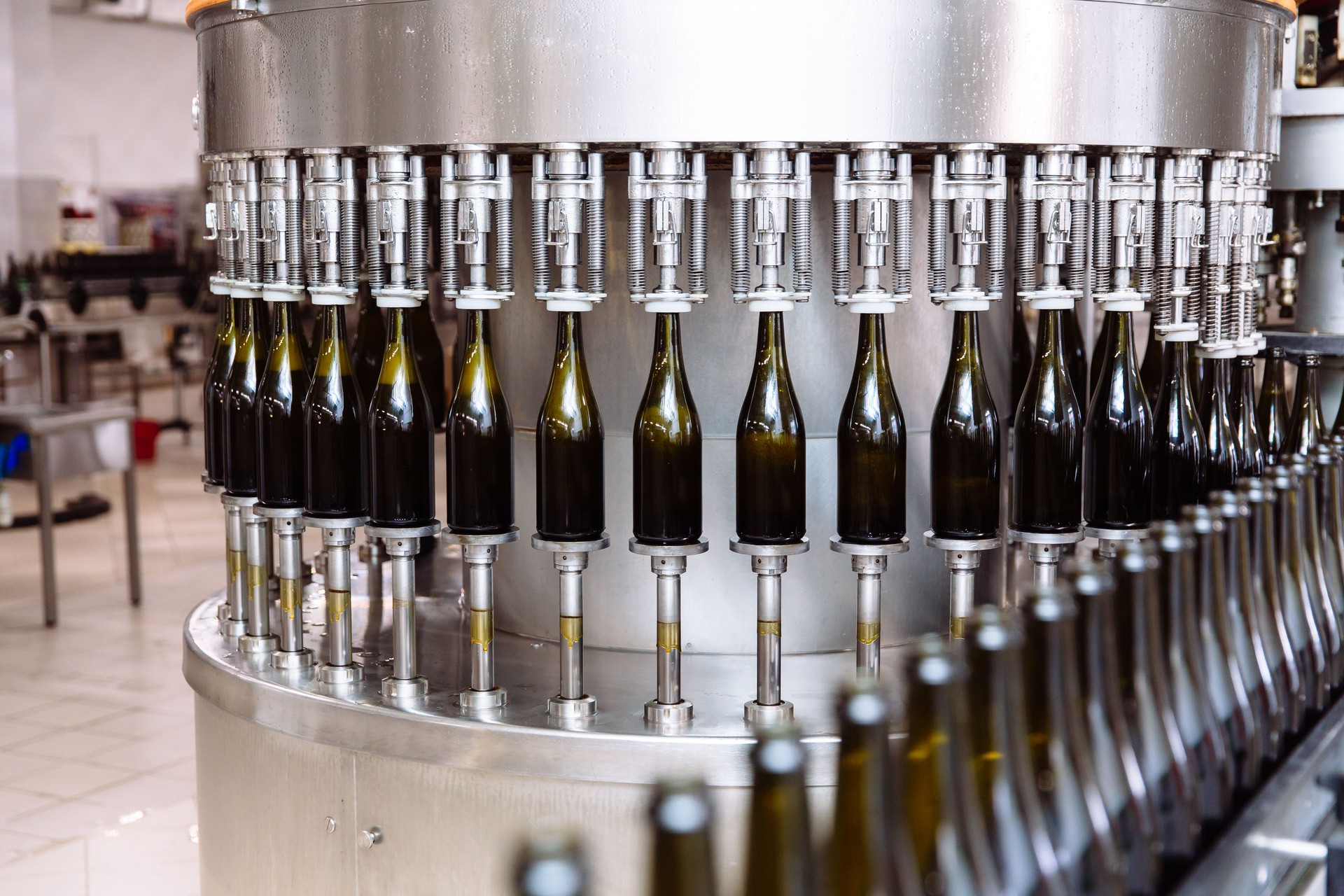 Glass bottles on the automatic conveyor line at the champagne or wine factory. Plant for bottling alcoholic beverages
